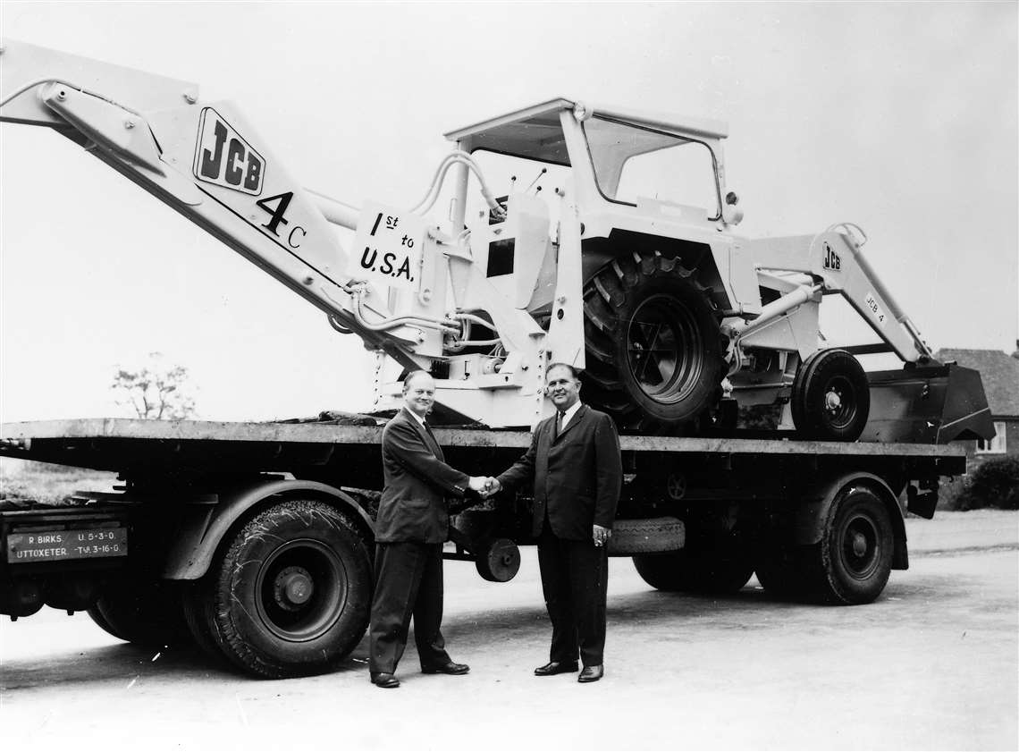 JCB exports its first machine, a 4C bakchoe, to the USA. Mr Bamford is pictured left