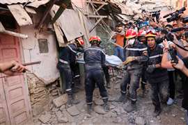 Los trabajadores de emergencia cargan un cadáver, tras un mortal terremoto, en Amizmiz, Marruecos, el 10 de septiembre de 2023. 
